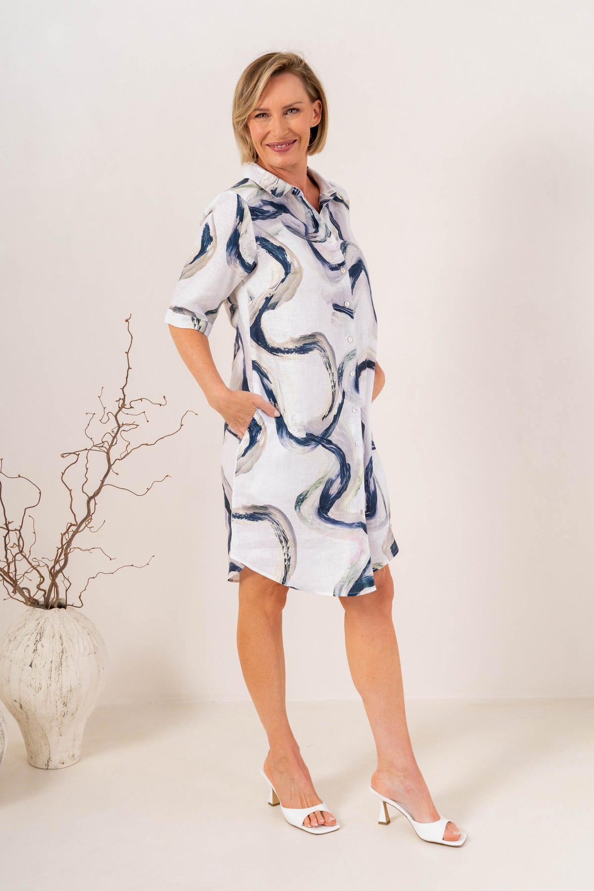 Woman modelling see saw linen shirtmaker style dress in riverstone print in studio setting.