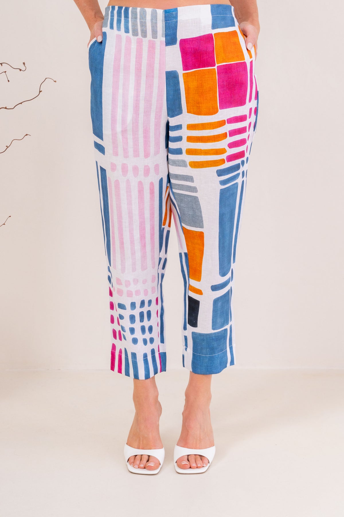 Woman modelling 100% linen See Saw pant in gallery print and in a 7/8 length. Modelling against a neutral studio background. 