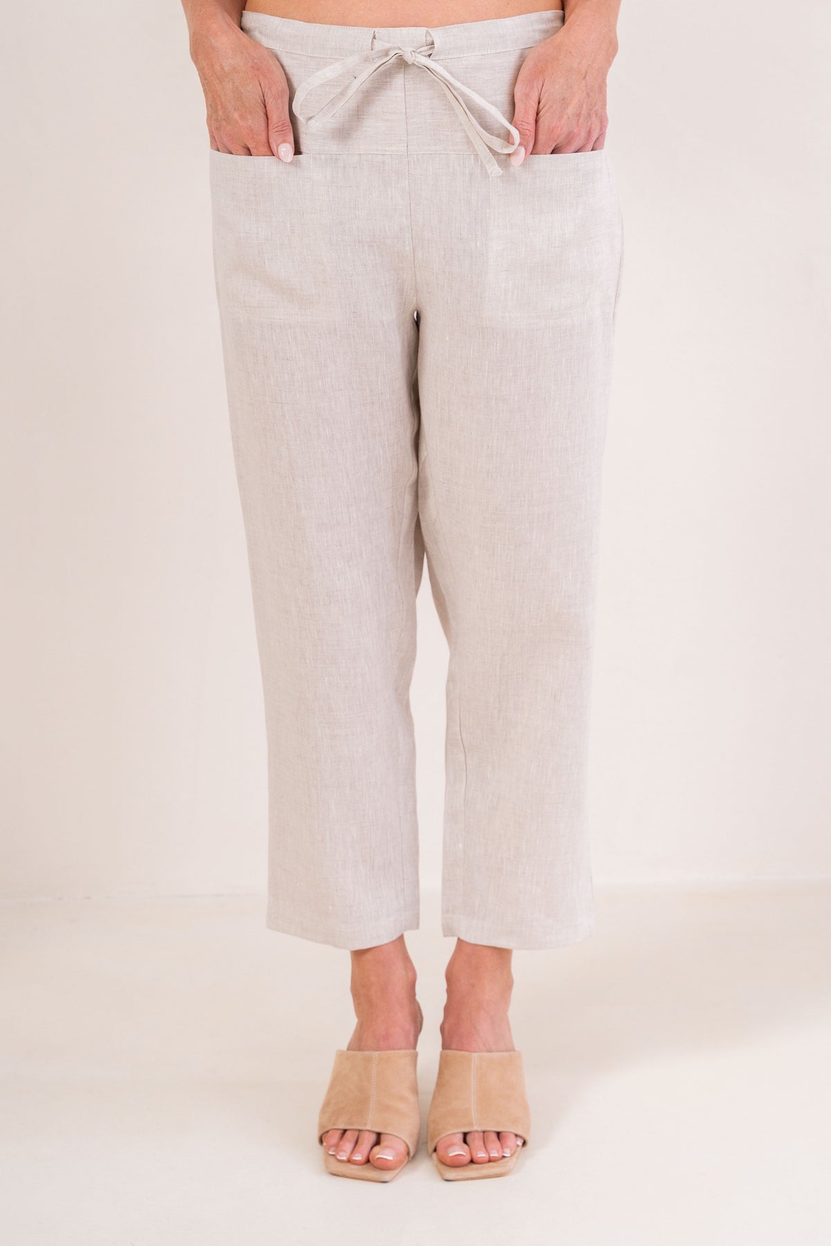 Woman wearing pink 100% linen pants by See Saw clothing.