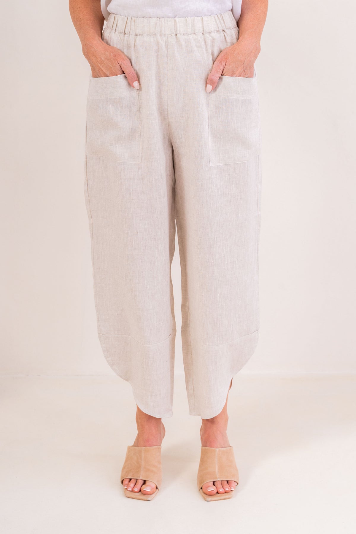 Women wearing 100% Linen See Saw top on stripe with a cap and  2 pocket pant in marigold against a neutral background
