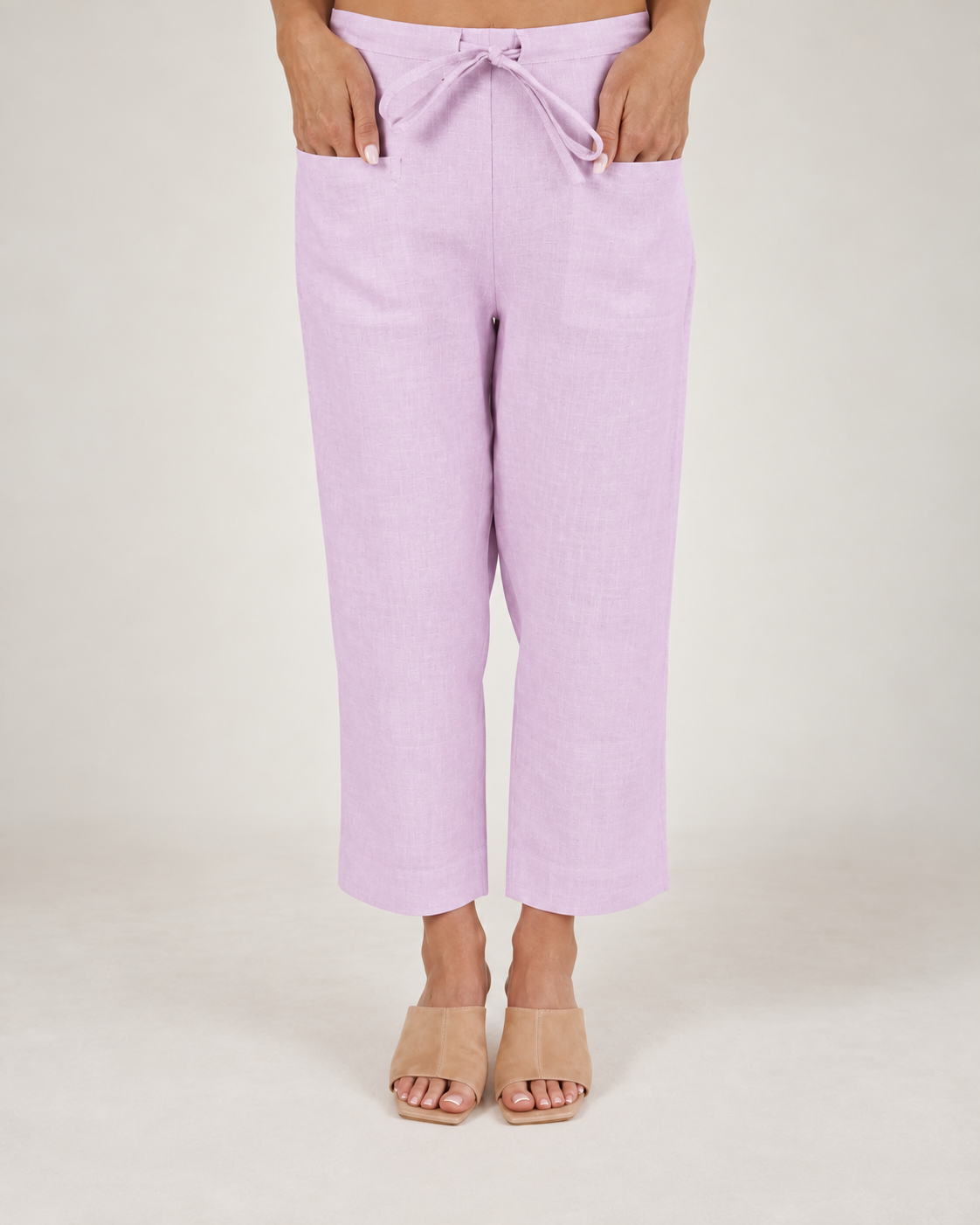 Woman wearing pink 100% linen pants by See Saw clothing.