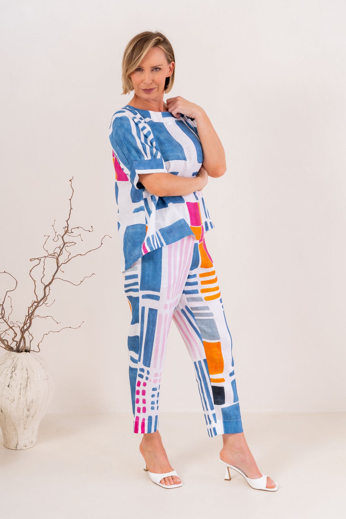 Woman modelling linen gallery print A line top with cuff sleeve by See Saw Clothing. Photo taken in a studio with a neutral background.