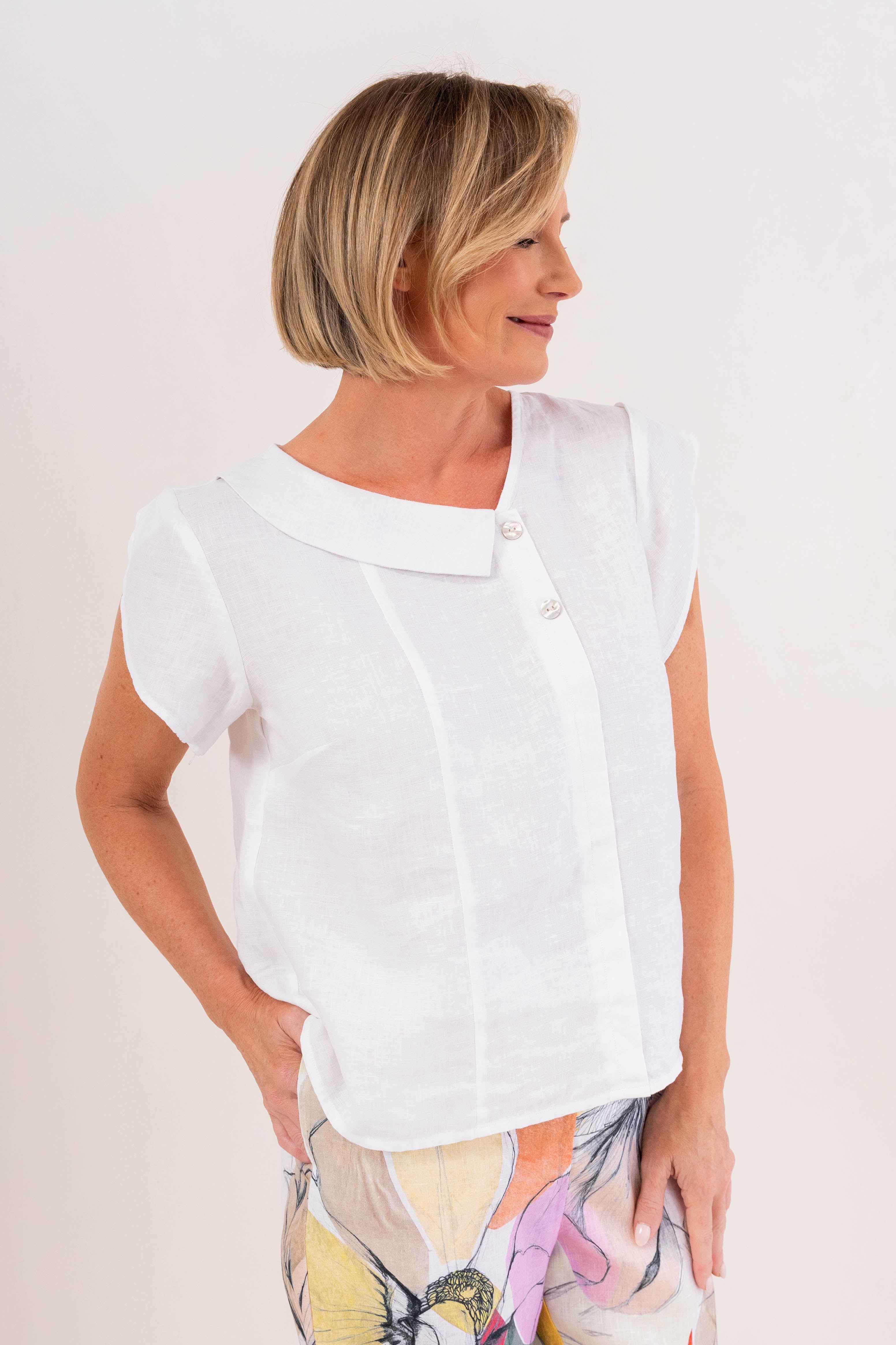 Model wearing see saw linen 2 button cowl neck top in navy.