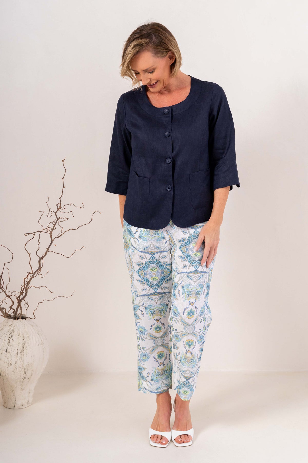 Woman modelling navy linen see saw utility jacket top and botanica 7/8 pants against a plain background. 