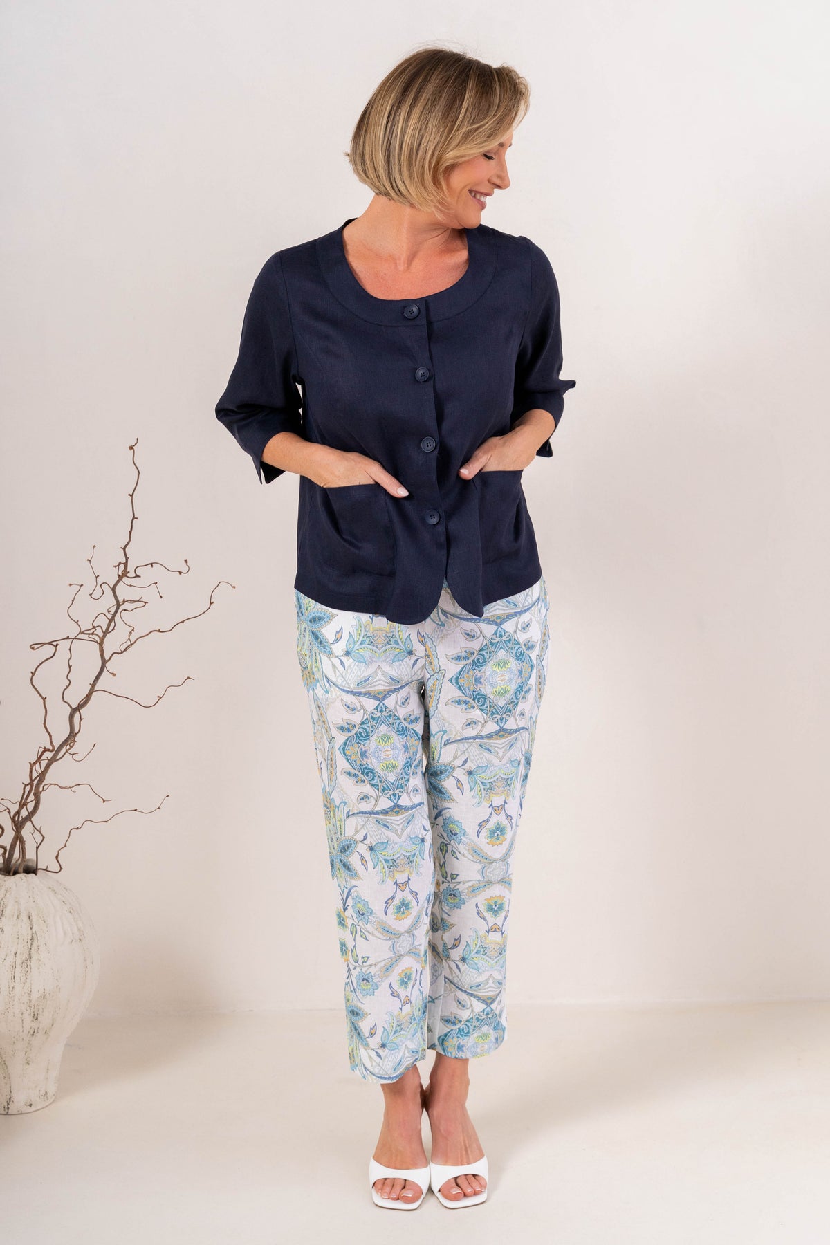 Woman modelling navy linen see saw utility jacket top and botanica 7/8 pants against a plain background. 
