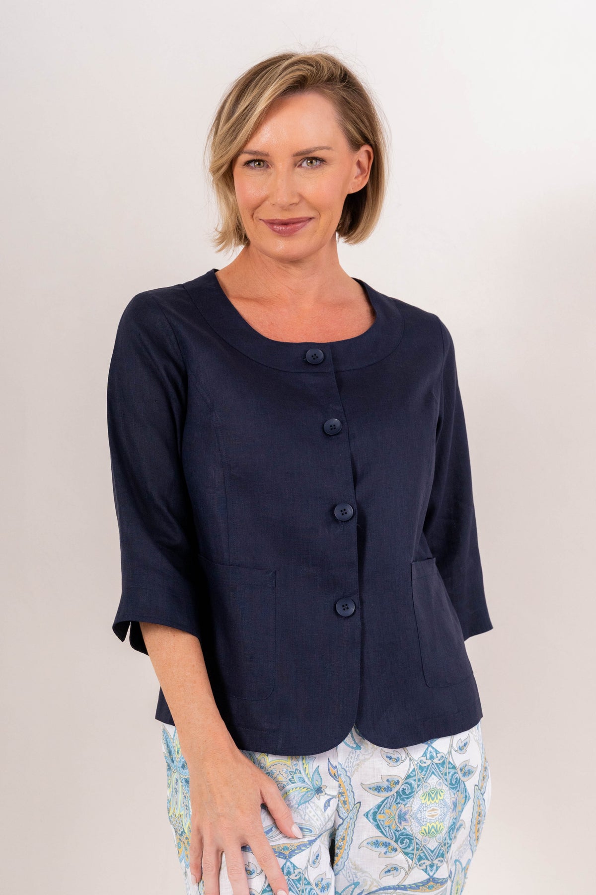 Woman modelling navy linen see saw utility jacket top against a plain background. 