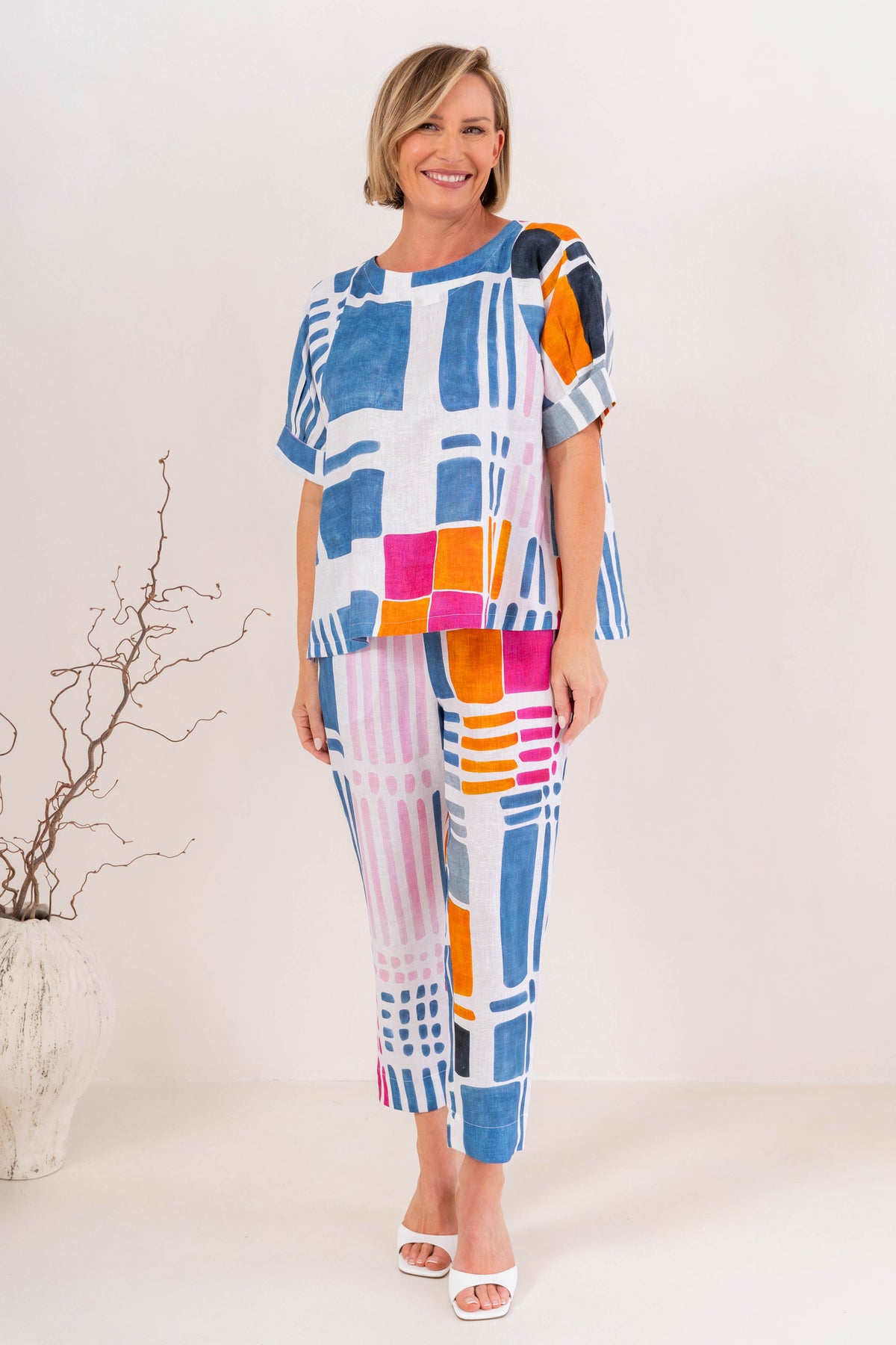 Woman modelling linen gallery print A line top with cuff sleeve by See Saw Clothing. Photo taken in a studio with a neutral background.
