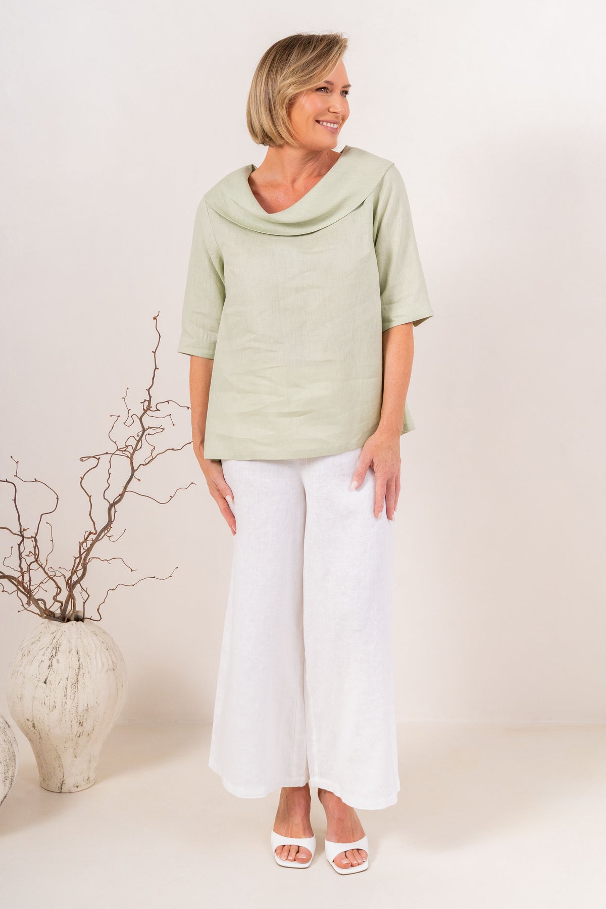 White wide-leg See Saw Palazzo linen pants shown on a model wearing white heeled sandals against a light beige background.