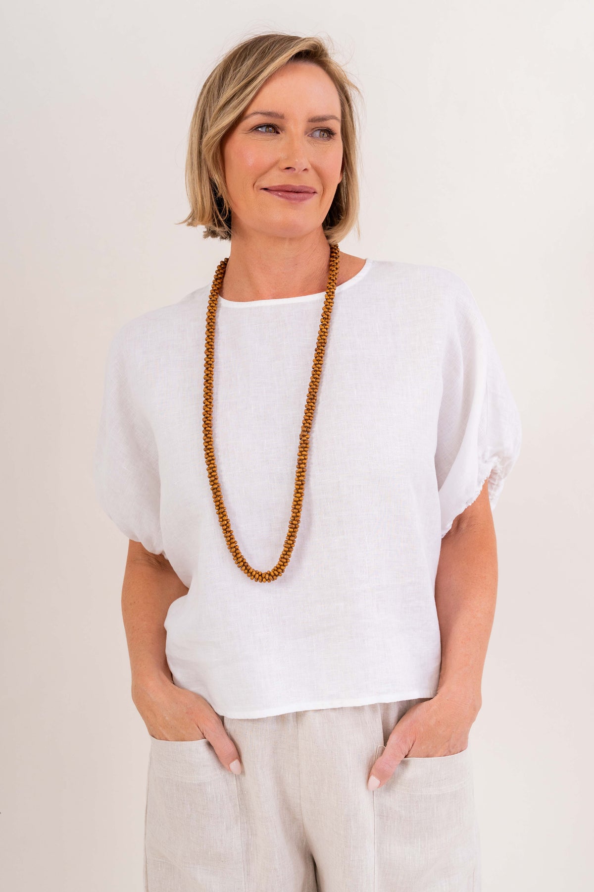 Model wearing white 100% linen elastic sleeve dress by See Saw