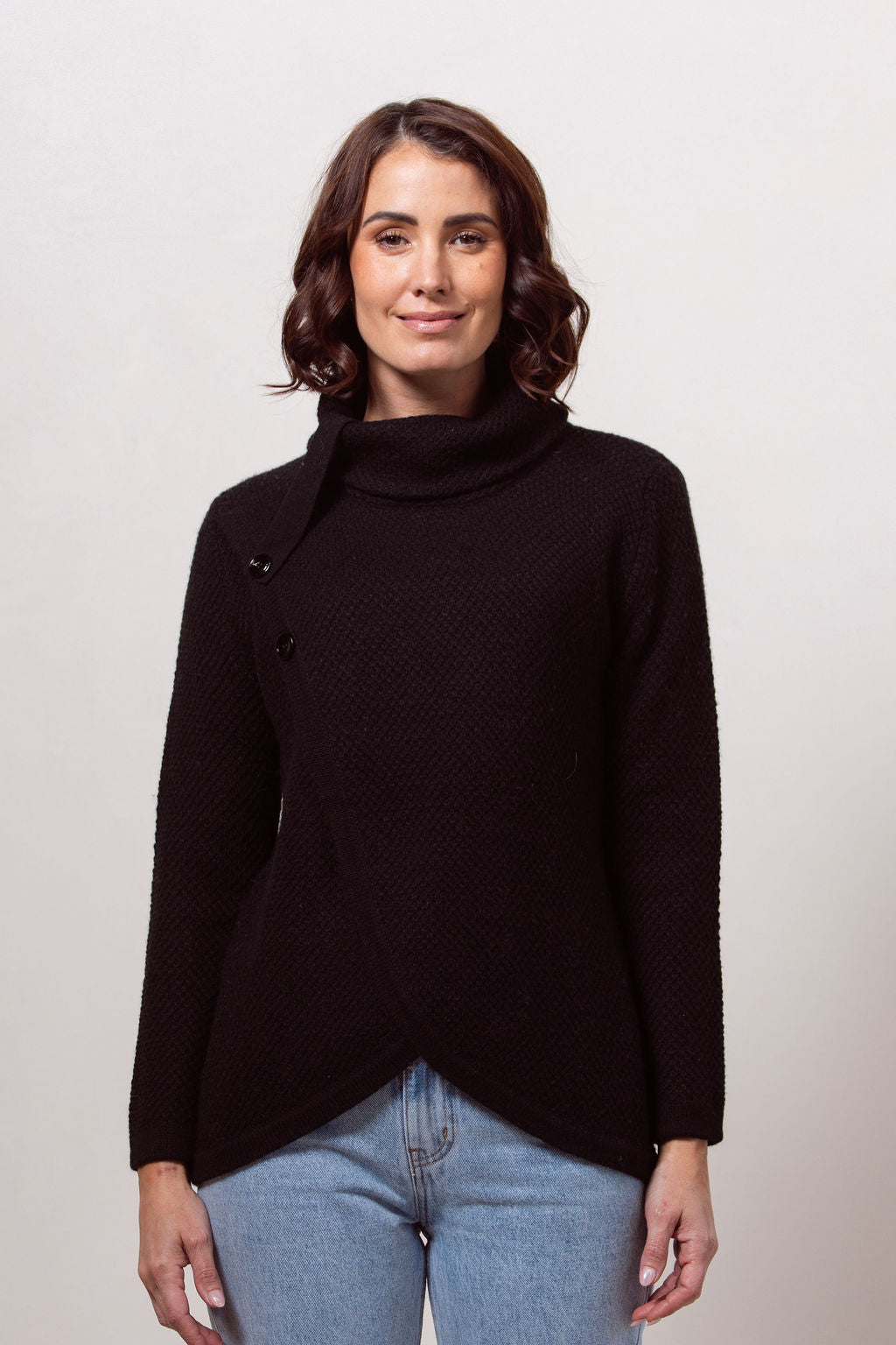 Woman wearing a black Cowl Neck Moss Stitch See Saw sweater with a white background