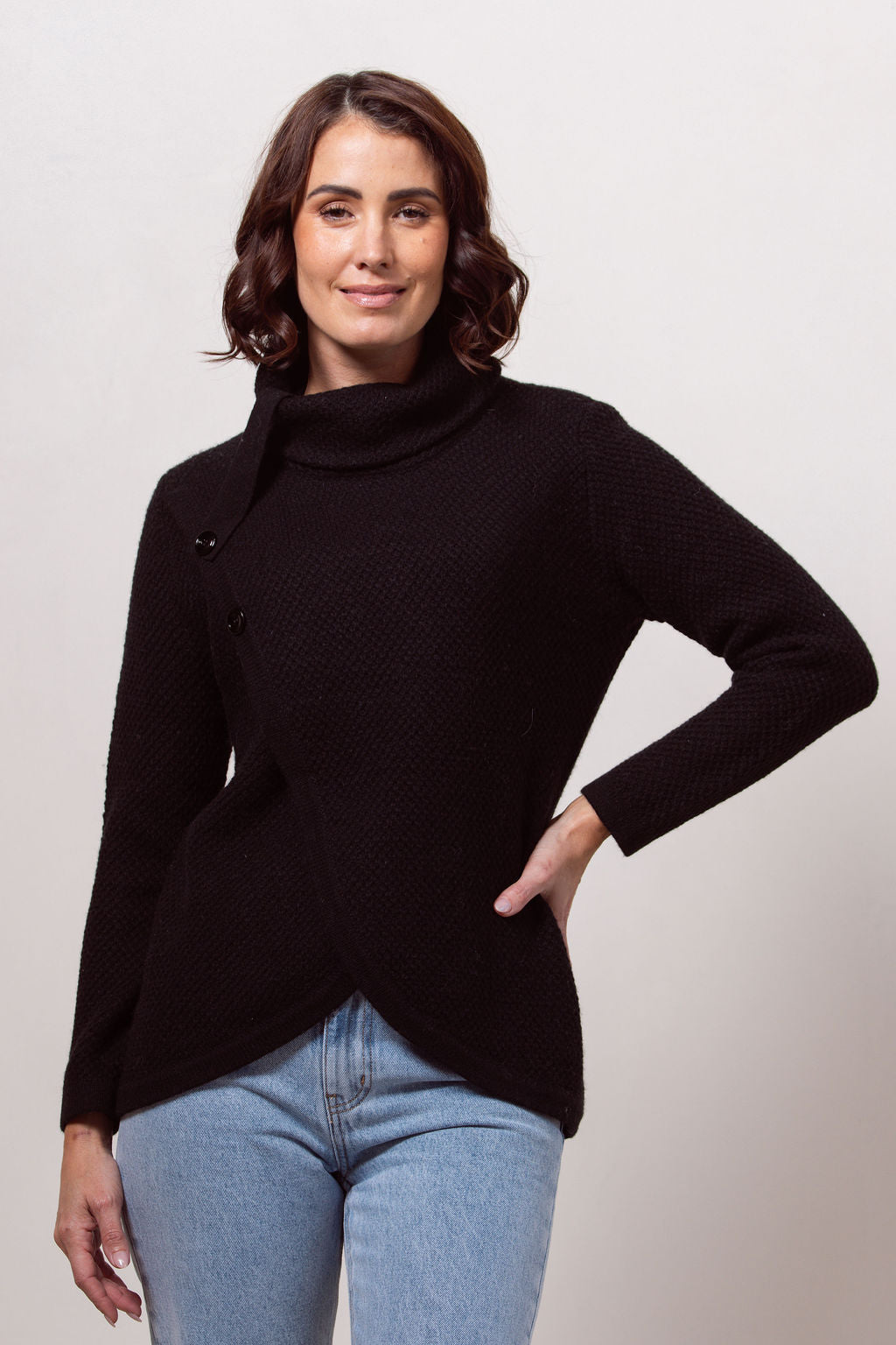 Woman wearing a black Cowl Neck Moss Stitch See Saw sweater with a white background