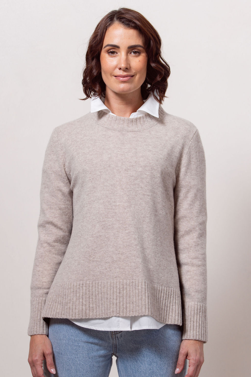 Woman wearing a Merino Wool See Saw sweater in wheat with Black accents on a plain background